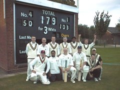 Promotion gaining second team pose in front of the score board with Jonesy and Lucky scoring 50 and 103 no respectively