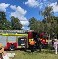 A group of people standing next to a fire truck AI-generated content may be incorrect.