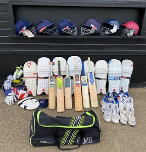 selection of cricket kit: gloves, pads, helmets,, bag